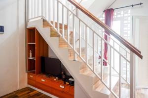 a staircase in a house with a television at Omah Ninten Syariah Laweyan RedPartner in Solo