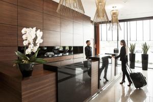 a man and a woman standing at a counter in a kitchen at GrandHotel Tiffi in Iława