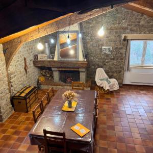 a dining room with a table and a fireplace at Les Gites de Costerousse - Ardèche in Nozières