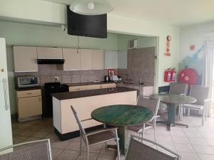 a kitchen with two tables and a counter with chairs at Brackendene Lodge in Gaborone