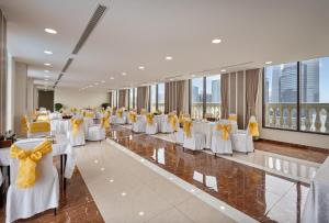 a banquet hall with white tables and yellow bows at Tao Dan Hotel in Ho Chi Minh City +50 photos
