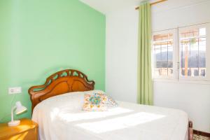 a bedroom with a bed with a wooden headboard and a window at Villa Capital Mountainview in Carboneras +22 photos