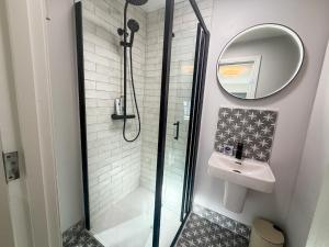 a bathroom with a shower and a sink and a mirror at Luxury 2-Bedroom Apartment Overlooking the Beach in Bundoran +22 photos