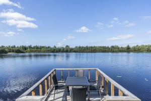a dock with a table and chairs on a lake at Ferienhaus Valle-Sjötomt Borshult in Diö