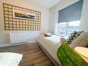 a small bedroom with a bed and a window at Luxury 2-Bedroom Apartment Overlooking the Beach in Bundoran