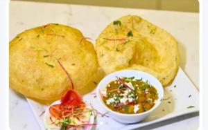 a plate of food with potatoes and a dipping sauce at Hotel Airport Fly Inn in Lucknow +30 photos