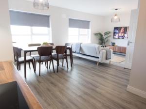 a living room with a table and chairs and a bedroom at Luxury 2-Bedroom Apartment Overlooking the Beach in Bundoran