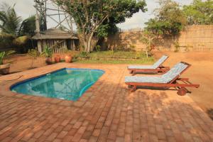 a patio with two lounge chairs and a pool at Cottage sur la mer in Vilanculos +4 photos
