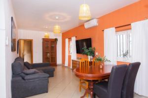 a living room with a table and chairs and a tv at Villa Capital Mountainview in Carboneras