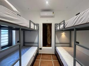 two bunk beds in a room with a hallway at Hostel Akeeka in Alleppey