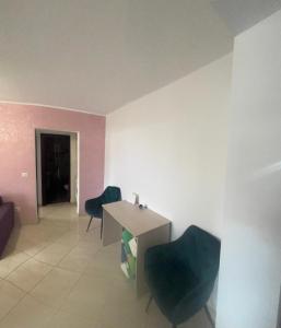 a room with a table and two blue chairs at KM 0 one RESIDENCE in Piatra Neamţ +25 photos