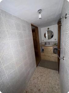 a bathroom with a shower with a tiled wall at petit chalet in Chamonix