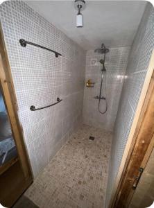 a bathroom with a shower with white tiles at petit chalet in Chamonix