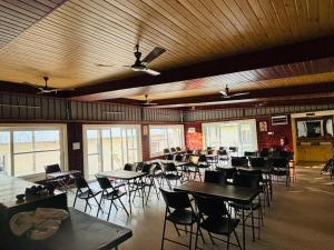 a dining room with tables and chairs and windows at Shivalik Resorts in Barkot