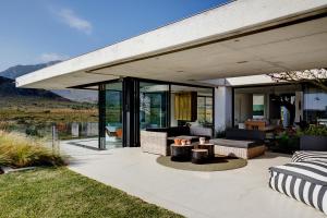 an outdoor patio with a view of the mountains at Restio River House in Pringle Bay
