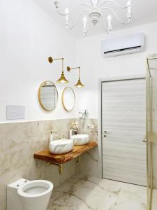 a bathroom with a toilet and two mirrors at B&B da Matteo in Telese