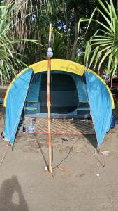 a blue and yellow tent sitting on the beach at Tenda Premium Pantai Madasari in Bulakbenda +2 photos