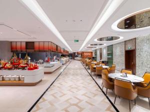 a restaurant with tables and chairs and a buffet at Pullman Wuxi New Lake in Wuxi