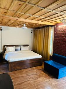 a bedroom with a bed and a blue couch at Shivalik Resorts in Barkot