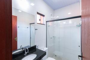 a bathroom with a sink and a glass shower at Pousada Pouso Vitoria in Pirenópolis +37 photos