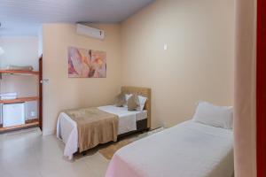 a bedroom with two beds and a window at Pousada Pouso Vitoria in Pirenópolis