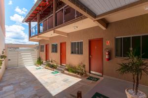 a house with red doors and a patio with plants at Pousada Pouso Vitoria in Pirenópolis
