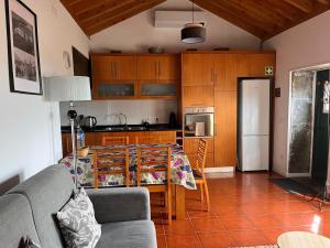 a living room with a table and a kitchen at Quintinha da Chinela in Porto Judeu