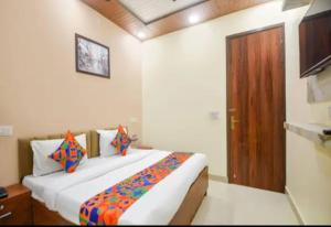 a bedroom with a large bed and a wooden door at Hotel Villa Getaway in New Delhi
