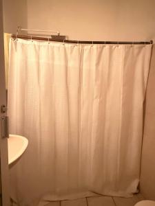 a bathroom with a shower curtain and a sink at Ohmen House in Guadalajara