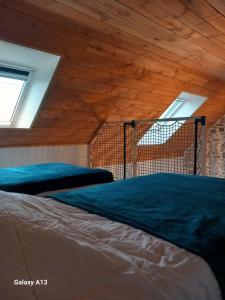a bed in a room with a wooden ceiling at Maisonnette cosy proche de la côte in Lesneven +2 photos