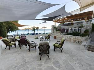 a group of chairs and tables on a patio at Phil Samosflats Beachfront Maisonettes in Potokáki
