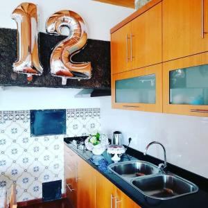 a kitchen with a sink and a number on the wall at Quintinha da Chinela in Porto Judeu +35 photos
