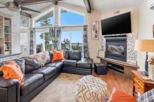 a living room with a leather couch and a fireplace at Sunset Cove AC Waterfront Kayaks in Tobermory