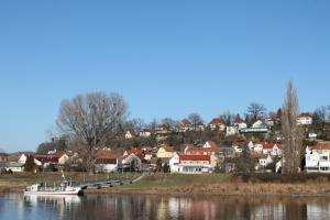 a small boat is docked at a dock on a river at City-Appartement Pirna in Pirna