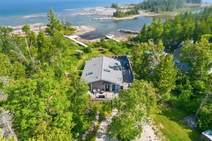 an aerial view of a house on a hill with trees at Sunset Cove AC Waterfront Kayaks in Tobermory