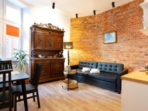 a living room with a couch and a brick wall at Apartamenty Bydgostia Dworzec in Bydgoszcz