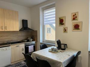 a kitchen with a table and some chairs and a kitchen with a table at Ferienwohnung Andi in Gerolstein +14 photos