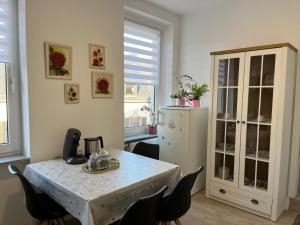 a dining room with a table and chairs and a refrigerator at Ferienwohnung Andi in Gerolstein