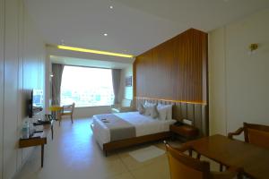a bedroom with a bed and a desk and a television at SUNDHA HOTEL palanpur in Pālanpur +161 photos