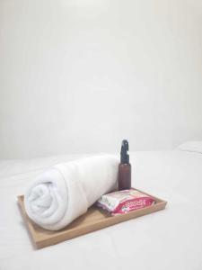 a white towel on a wooden shelf with a bottle of soap at 953 D shore 1 in Manila +34 photos