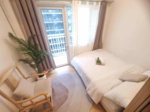a bedroom with a bed and a chair and a window at 953 D shore 1 in Manila