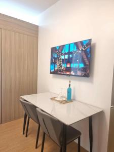a white table with two chairs and a tv on the wall at 953 D shore 1 in Manila