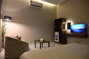 a living room with a bed and a television at شقق وغرف الرصف in Hail