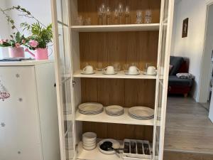 a glass cabinet with plates and dishes on it at Ferienwohnung Andi in Gerolstein
