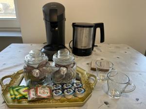 a tray with cupcakes and a coffee maker on a table at Ferienwohnung Andi in Gerolstein