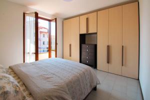 a bedroom with a bed and cabinets and a television at La casa di a-mici in Maccagno Superiore