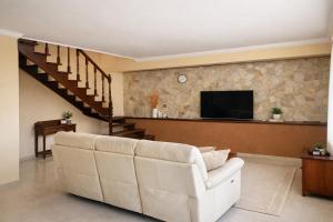 a living room with a couch and a tv at Limoneto Etna View in Giarre +35 photos