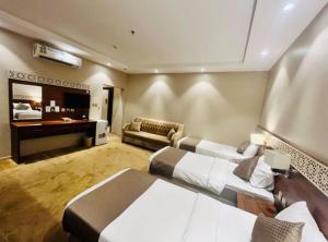 a large room with two beds and a desk at فندق صها in Ash Shishah +8 photos