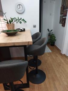 a dining room table with two chairs and a clock on the wall at Angel's Luxury Studio in Olympiada