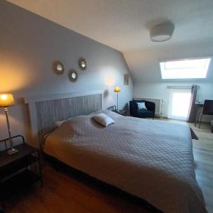 a bedroom with a bed and two mirrors on the wall at Le Relais De La Motte in Soignies